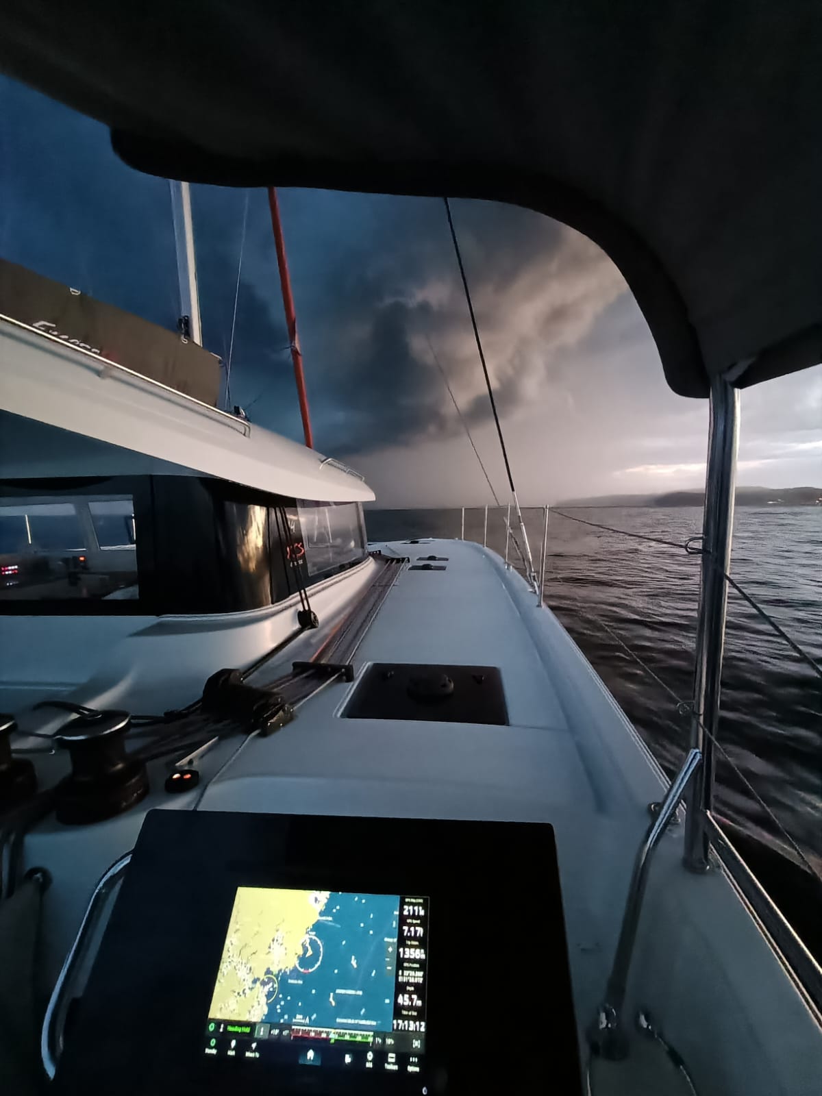 Excess 14 catamaran on a yacht delivery to Sydney with huge storm clouds in the back ground and the chart plotter is illuminated